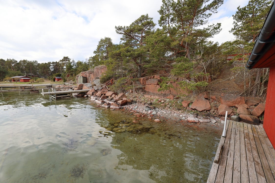 Strandområde med fritidsbostäder, garage och båthus i Degersand i Eckerö