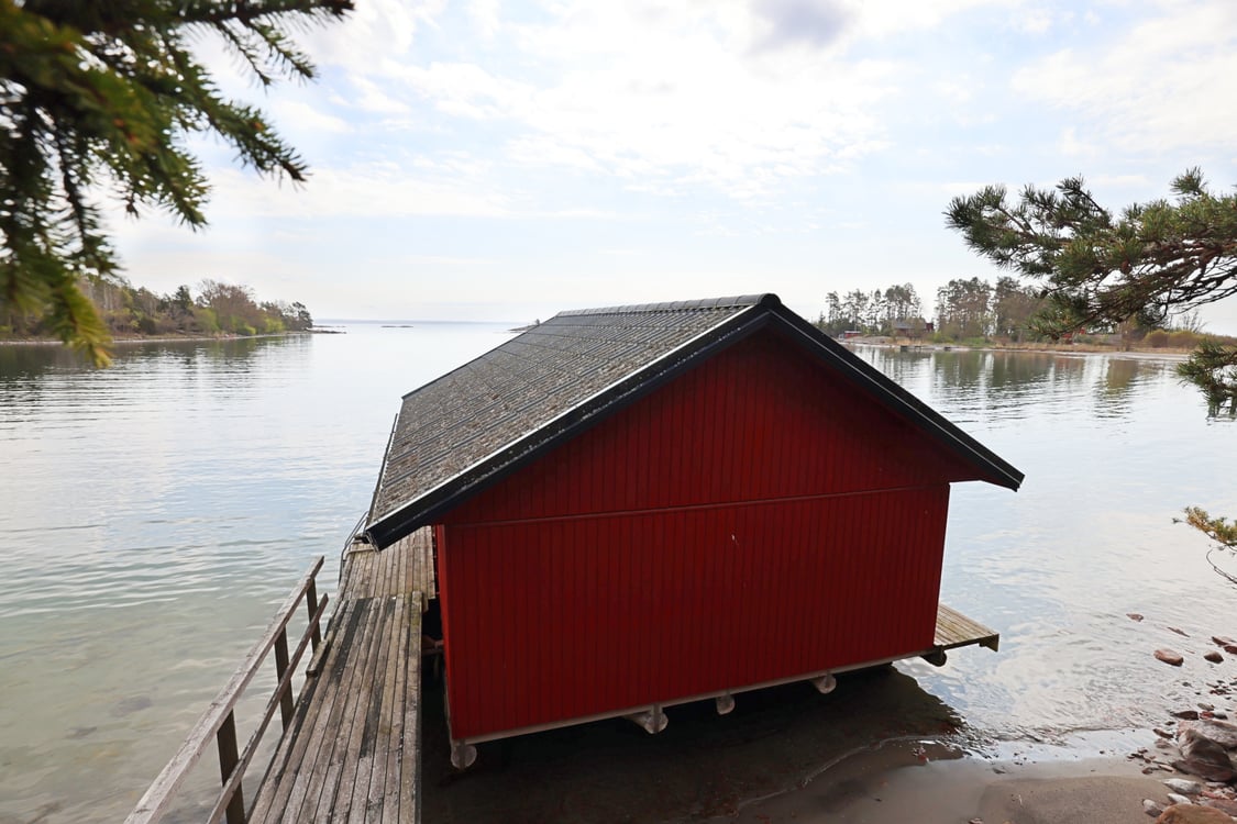 Strandområde med fritidsbostäder, garage och båthus i Degersand i Eckerö
