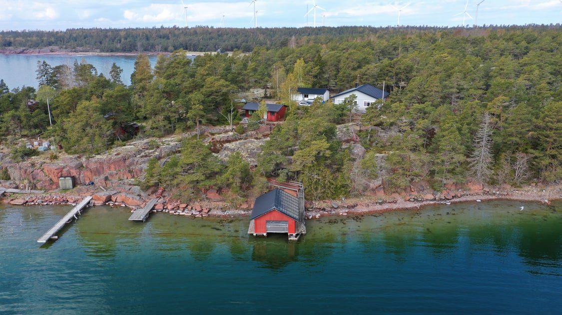 Strandområde med fritidsbostäder, garage och båthus i Degersand i Eckerö